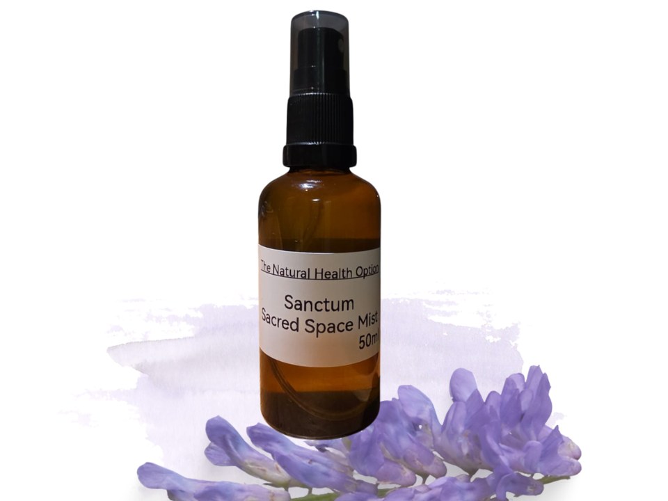 Sanctum Sacred Space Mist in an amber spray bottle beside a sprig of lavender